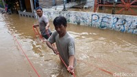 Mereka memasang tambang untuk proses evakuasi korban banjir.