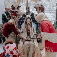 Persiapan malam Bainai dimulai dari jam tiga sore, yang sebenarnya acara mulai di jam delapan malam. Aku sengaja untuk dandan sangat lebih awal karena aku mau dandan dengan tenang dan tidak terburu-buru. Memulai dengan bismillah, aku dandan dan mencoba untuk fokus, tulisnya. Foto: Instagram @abellyc, @thepotomoto