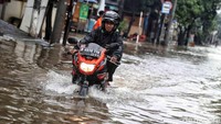 Agar tetap dapat beraktivitas ada pula warga yang nekat menerobos banjir dengan menggunakan sepeda motor.