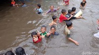 Lantaran tak ada kendaraan yang lewat, mereka leluasa loncat dan berenang di sepanjang Underpas Gonggo.