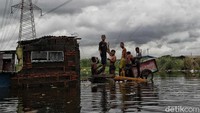 Sejumlah warga tampak beraktivitas di area sekitar tempat tinggal mereka yang terendam banjir di Kampung Kandang, Semper Barat, Jakarta Utara.