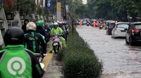Agar dapat tetap beraktivitas sejumlah pemotor pun melintasi trotoar guna menghindari banjir.