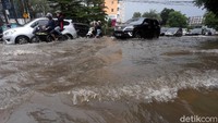Sejumlah kendaraan roda dua dan roda empat menerobos genangan banjir di jalan yang berada di kawasan Bekasi.