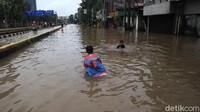 Beberapa anak-anak memanfaatkan banjir untuk bermain.