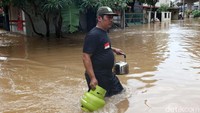Seorang warga membawa tabung gas untuk dipakai di lokasi pengungsian.