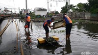 Sejumlah petugas sedang memeriksa dan memperbaiki perangkat wesel kereta yang terendam di kawasan Stasiun Pasar Senen.