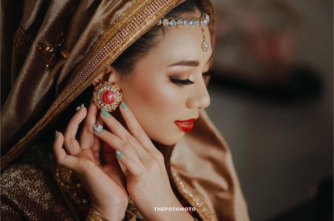 Untuk acara Malam Bainai, makeup Abel menyesuaikan busana khas Minang yang dikenakannya. Ketika itu, Abel tampak mengenakan lipstik merah dan riasan mata bernuansa emas. Foto: Instagram @abellyc, @thepotomoto