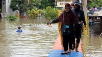 Satu per satu warga melintasi jembatan apung tersebut.