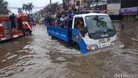 Selain alat berat, truk Satpol PP juga digunakan untuk membantu warga menerjang banjir di kawasan Kedoya Green Garden, Jakarta.