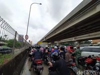 Pemotor antre masuk gerbang tol Becakayu untuk hindari banjir. 
