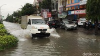 Hanya kendaraan berbadan besar yang berani melintas di jalanan yang terendam banjir.