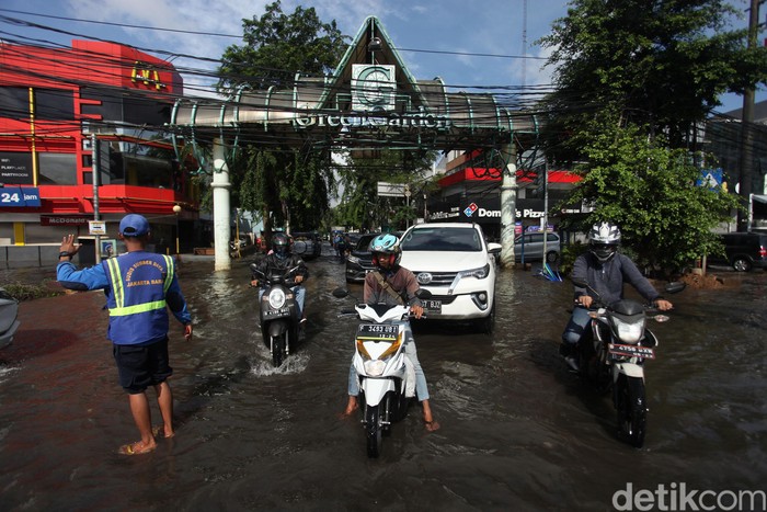 Sejumlah kendaraan melintas di perempatan Green Garden, Jakarta Barat, Rabu (26/2/2020). Hingga pagi ini terpantau jalanan masih tergenang.