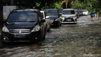 Genangan banjir sedikit menyumbat kendaraan yang melintas.