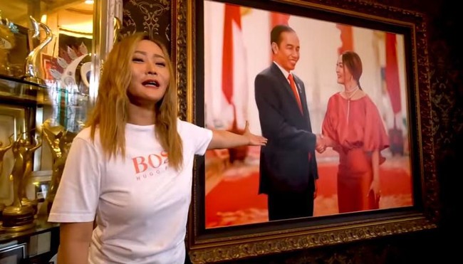 Dekorasi yang paling menonjol dari ruang tamu di rumah mewah Inul Daratista adalah lukisan Jokowi bersalaman dengan sang pedangdut yang berukuran sangat besar. Kata Istri Adam Suseno itu, lukisan itu merupakan gambar ulang dari fotonya bersama Jokowi. Dia merasa sangat berkesan dengan pengalamannya bertemu Presiden Jokowi. Orang ndeso, rakyat jelata bisa bersalaman dengan presiden itu kan luar biasa, ujarnya. Foto: Dok. YouTube Inul Daratista Official
