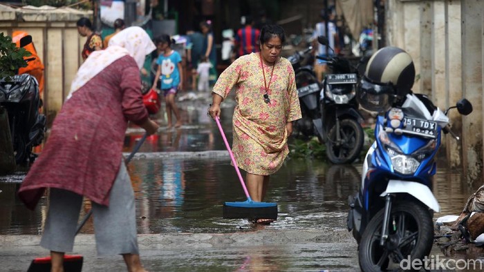 Banjir yang mulai surut di kawasan Cipinang Melayu, Jakarta Timur, dimanfaatkan warga untuk bersih-bersih rumah.