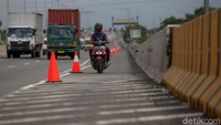 Banjir yang masih menggenangi sebagian ruas jalan Cakung Cilincing Raya membuat pemotor diperbolehkan masuk tol.