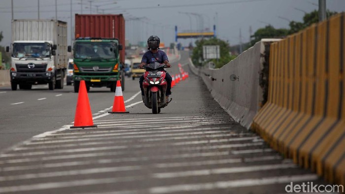 Pemotor diperbolehkan melintas di jalan tol lingkar luar timur, Cilincing, Jakarta Utara. Hal ini karena sebagian ruas jalan Cakung Cilincing Raya terendam banjir.