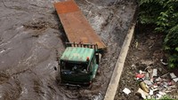 Ketinggian air menutup ban truk-truk tersebut.