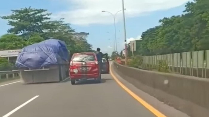 Pengemudi nyetir berdiri sambil buka pintu mobil di Makassar (Screenshot video viral)