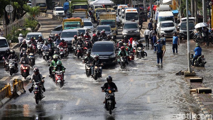 Sejumlah kendaraan melintas di perempatan Green Garden, Jakarta Barat, Rabu (26/2/2020). Hingga pagi ini terpantau jalanan masih tergenang.