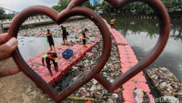 Petugas UPK Badan Air Jakarta bahu membahu membersihkan sampah yang mengotori sungai.