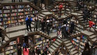 Zhongshuge Bookstore punya tema unik, yaitu labirin dan cermin. Berlokasi di Chongqing, China pantulan tangga dari cermin menggambarkan jaringan laba-laba besar yang memenugi toko. (Getty Images)