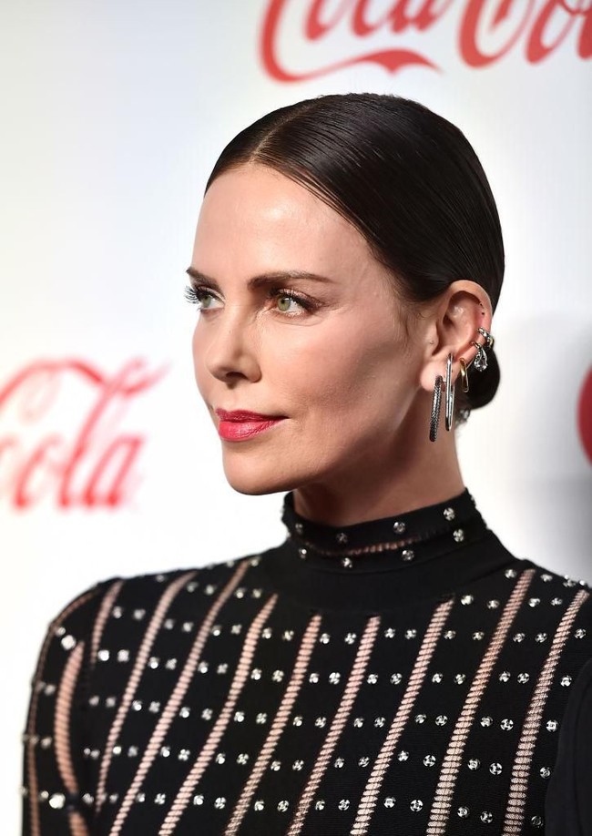 Tidak hanya 2-3 anting, tapi tren yang sekarang ini berkembang adalah mengenakan banyak anting sekaligus di satu daun telinga. Charlize Theron yang dikenal suka bereksperimen gaya pun mengadaptasi tren ini untuk tampil di red carpet. Foto: Astrid Stawiarz/Getty Images