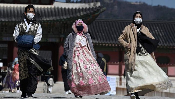 Visitors wearing face masks walk near the Gwanghwamun, the main gate of the 14th-century Gyeongbok Palace, and one of South Koreas well-known landmarks, in Seoul, South Korea, Saturday, Feb. 22, 2020. South Korea on Saturday reported a six-fold jump in viral infections in four days to 346, most of them linked to a church and a hospital in and around the fourth-largest city where schools were closed and worshipers and others told to avoid mass gatherings. (AP Photo/Lee Jin-man)