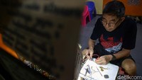 Koh Hendra Aseng tengah memperbaiki jam tangan salah satu pelanggannya di Jakarta.