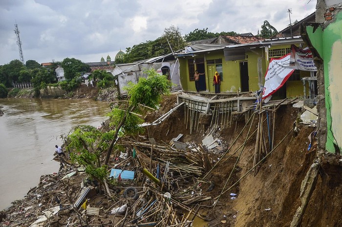 Warga mengamati rumahnya yang ambles akibat terkikis aliran kali daerah Teluk Pucung, Bekasi Utara, Jawa Barat,  Rabu (26/2/2020). Menurut warga, 34 rumah di bantaran aliran Kali Bekasi tersebut ambles sejak tahun 2017, tujuh rumah hilang dan 27 rusak berat. ANTARA FOTO/Fakhri Hermansyah/wsj.