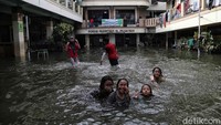 Sejumlah anak tampak asyik berenang dan bermain air saat banjir merendam kawasan Teluk Gong, Jakarta, Kamis (27/2/2020).