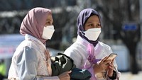 Namun masker tetap menjadi barang yang wajib digunakan walau cuma berfoto. (AFP)