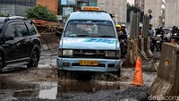 Beberapa angkot nekat menerobos genangan akibat jalan yang rusak. Pradita Utama/detikcom.