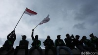 Massa Ojol juga mengibarkan bendera merah putih sepanjang aksi.