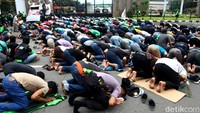 Di sela-sela aksi unjuk rasa tersebut, massa pengemudi Ojol dan sejumlah petugas kepolisian turut melaksanakan salat Jumat.