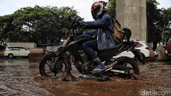 Sejumlah kendaraan melintas di Jalan Boulevard Raya yang rusak kawasan Kelapa Gading, Jakarta Utara, Jumat (28/2). Menurut keterangan warga jalan tersebut rusak karena proyek jalan tol dan akibat dampak banjir yang memperparah kerusakan sehingga jalanan menjadi penuh lubang dan becek menyebabkan bahaya kepada pengendara motor.