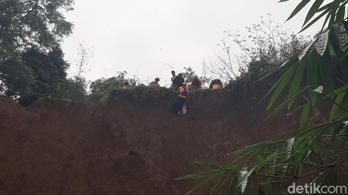 Petugas evakuasi jenaah di bibir tebing yang longsor