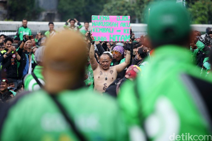 Massa driver ojek online (ojol) berdemo di depan Gedung DPR RI, Jakarta, Jumat (28/2/2020). Mereka meminta Wakil Ketua Komisi V Nurhayati Monoarfa mundur.