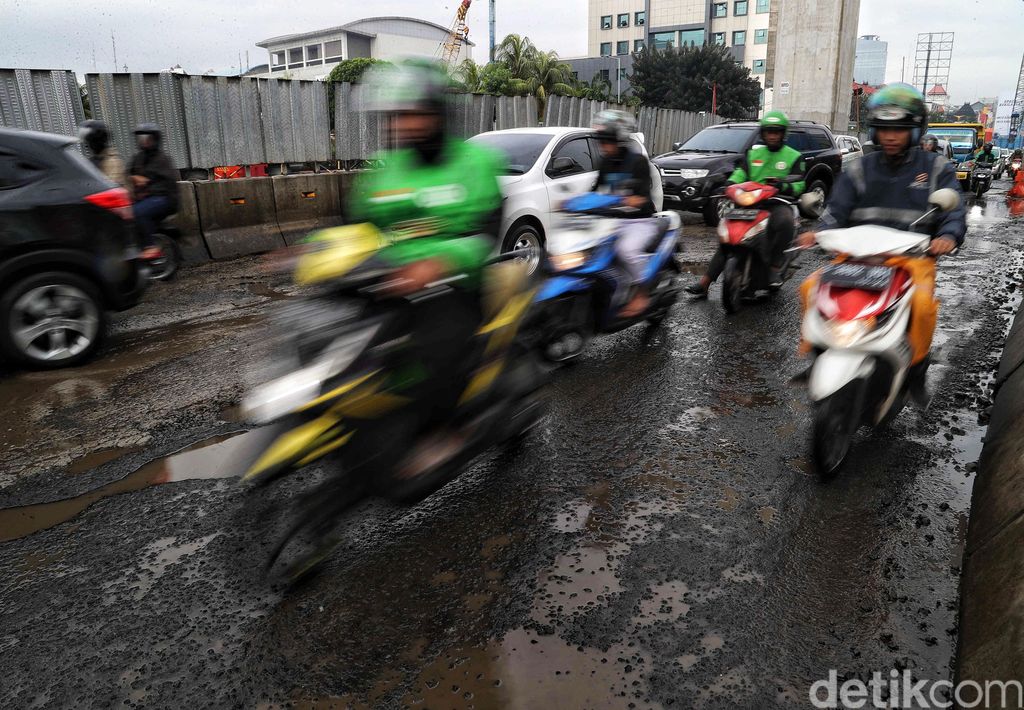 Sejumlah kendaraan melintas di Jalan Boulevard Raya yang rusak kawasan Kelapa Gading, Jakarta Utara, Jumat (28/2). Menurut keterangan warga jalan tersebut rusak karena proyek jalan tol dan akibat dampak banjir yang memperparah kerusakan sehingga jalanan menjadi penuh lubang dan becek menyebabkan bahaya kepada pengendara motor.
