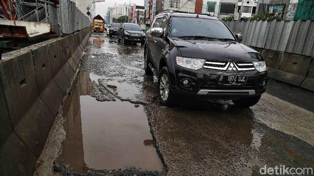 Sejumlah kendaraan melintas di Jalan Boulevard Raya yang rusak kawasan Kelapa Gading, Jakarta Utara, Jumat (28/2). Menurut keterangan warga jalan tersebut rusak karena proyek jalan tol dan akibat dampak banjir yang memperparah kerusakan sehingga jalanan menjadi penuh lubang dan becek menyebabkan bahaya kepada pengendara motor.