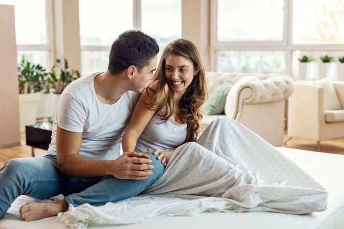 Suami dan istri Young loving couple enjoying in their morning time and talking to each other in bedroom.
