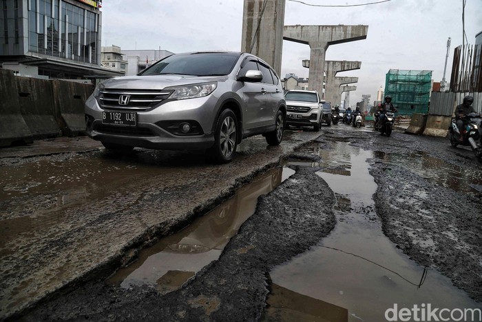 Sejumlah kendaraan melintas di Jalan Boulevard Raya yang rusak kawasan Kelapa Gading, Jakarta Utara, Jumat (28/2). Menurut keterangan warga jalan tersebut rusak karena proyek jalan tol dan akibat dampak banjir yang memperparah kerusakan sehingga jalanan menjadi penuh lubang dan becek menyebabkan bahaya kepada pengendara motor.