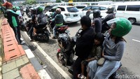 Tampak sejumlah pengemudi ojek online yang masih mengangkut penumpang berhenti di pinggir jalan guna mengganti jaket mereka.