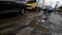 Sejumlah kendaraan melintas di Jalan Boulevard Raya yang rusak di kawasan Kelapa Gading, Jakarta Utara, Jumat (28/2/2020). Pradita Utama/detikcom.
