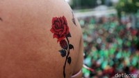Tampak tato bergambar bunga mawar merah menghiasi peserta aksi di DPR.