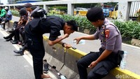 Tampak salah seorang warga memanfaatkan air botolan untuk berwudhu.