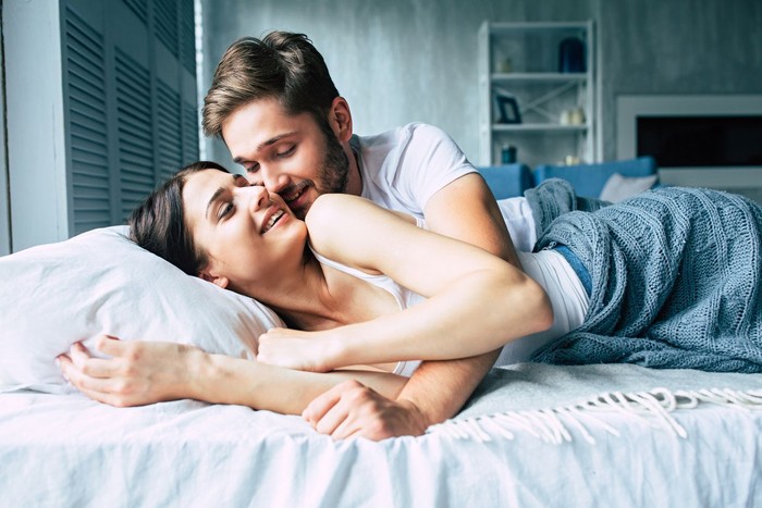 Suami dan istri Young loving couple enjoying in their morning time and talking to each other in bedroom.