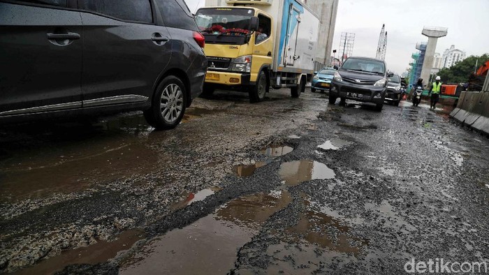 Sejumlah kendaraan melintas di Jalan Boulevard Raya yang rusak kawasan Kelapa Gading, Jakarta Utara, Jumat (28/2). Menurut keterangan warga jalan tersebut rusak karena proyek jalan tol dan akibat dampak banjir yang memperparah kerusakan sehingga jalanan menjadi penuh lubang dan becek menyebabkan bahaya kepada pengendara motor.
