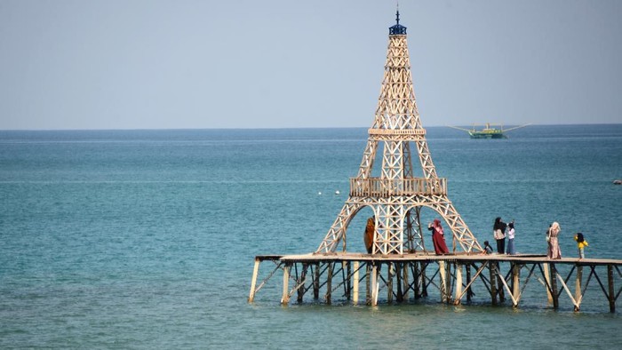 Pengunjung menikmati pemandangan bahari di kafe terapung dengan bangunan menyerupai menara eiffel di Pantai Wisata Desa Bayeun Kecamatan Leupung, Kabupaten Aceh Besar, Aceh, Sabtu (29/2/2020). Pemerintah bekerjasama dengan Bank Indonesia terus memperkuat sektor wisata  melalui kegiatan Meeting, Incentive, Convention and Exhibition (MICE) di daerah wisata dan selain mensubsidi ongkos pesawat, membebaskan pajak hotel, restoran dan tempat hiburan malam agar tidak terdampak virus corona. ANTARA FOTO/Ampelsa/ama.