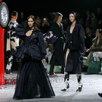 Penampilan Bella Hadid semakin mencuri perhatian berkat rok lipitnya yang transparan. Gaun tersebut sukses mengakomodasi keseksian model 23 tahun itu. Foto: Getty Images/Thierry Chesnot